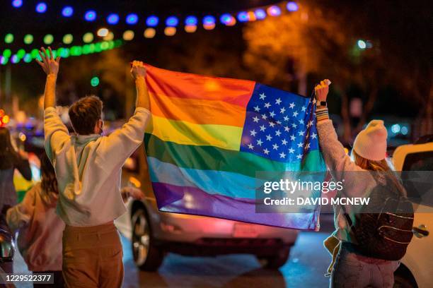 People wave a rainbow flag as they celebrate the victory of Joe Biden in the 2020 presidential election in West Hollywood, California, on November 7,...