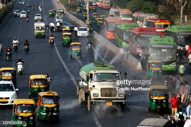 An EDMC truck sprinkles water on the road to curb pollution, at Anand Vihar, on November 7, 2020 in New Delhi, India. Delhi's Air Quality Index was...