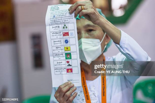 An election official counts votes at a polling station in a Buddhist temple after polls closed in Yangon on November 8, 2020.