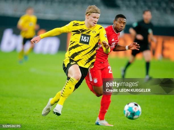 Dortmund's Norwegian forward Erling Braut Haaland and Bayern Munich's Austrian defender David Alaba vie for the ball during the German first division...