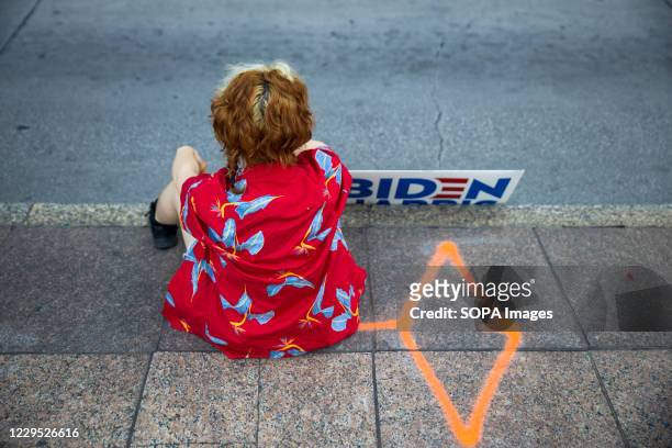 Biden supporter sits outside the Ohio State House to celebrate after his win as the 46th President of The United States was announced.
