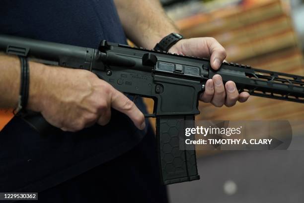 Customer handles an AR-15 at Jimmy's Sport Shop in Mineola, New York on September 25, 2020. - Gun store owners on Long Island have been selling out...