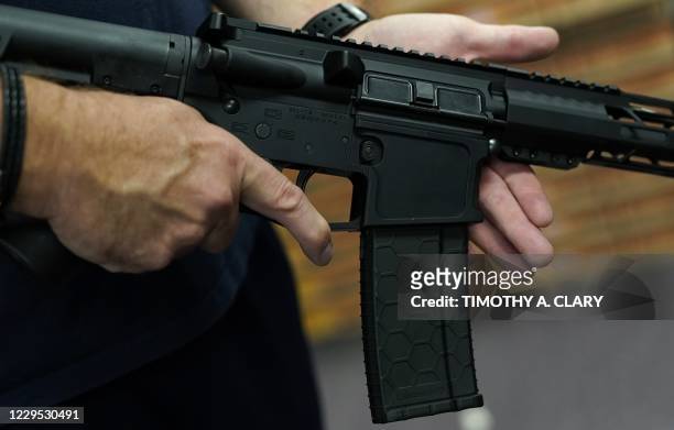 Customer handles an AR-15 at Jimmy's Sport Shop in Mineola, New York on September 25, 2020. - Gun store owners on Long Island have been selling out...