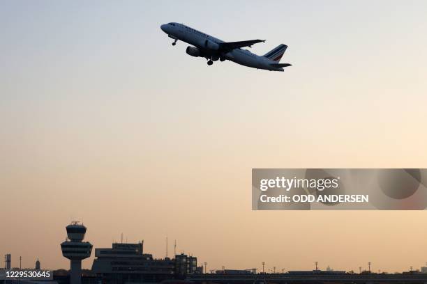 An aircraft of French airline Air France, the last plane to take off from Tegel 'Otto Lilienthal' Airport, flies over the airport's main terminal and...