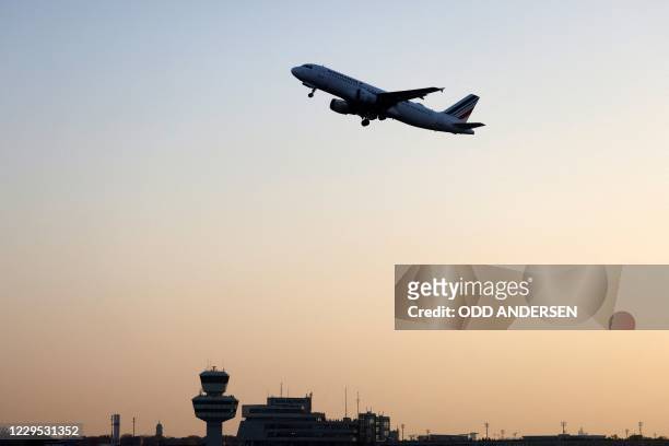 An aircraft of French airline Air France, the last plane to take off from Tegel 'Otto Lilienthal' Airport, flies over the airport's main terminal and...