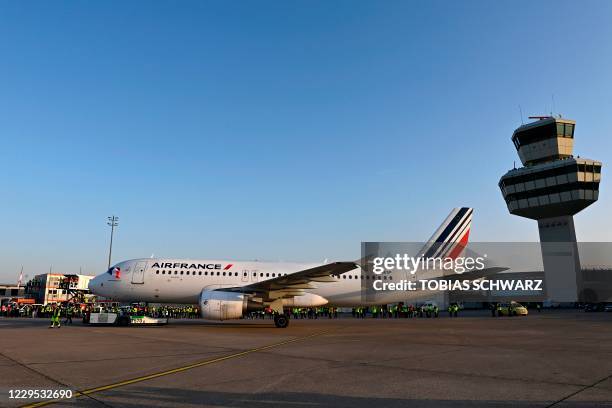 Airport and Air France personnel watch as an aircraft of French airline Air France, the last plane to take off from Tegel 'Otto Lilienthal' Airport,...