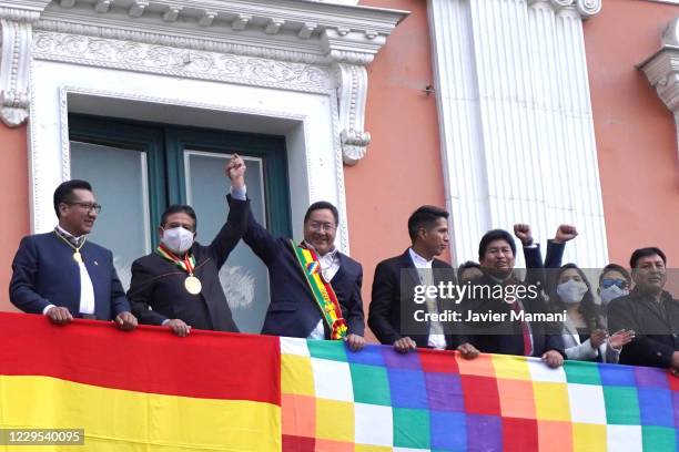 Newly elected President of Bolivia Luis Arce holds hands with his Vice President David Choquehuanca from a balcony of the Quemado Presidential Palace...