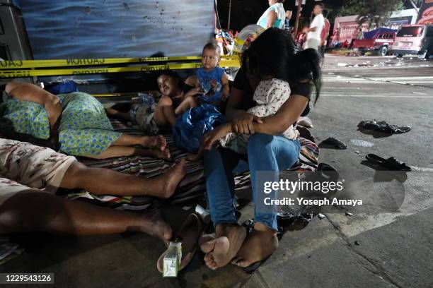 Mothers with their children rest on a small mattress on East Boulevard on November 7, 2020 in San Pedro Sula, Honduras. Eta entered Nicaragua as a...