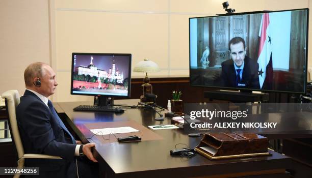 Russian President Vladimir Putin holds a meeting with his Syrian counterpart Bashar al-Assad via a video conference call at the Novo-Ogaryovo state...