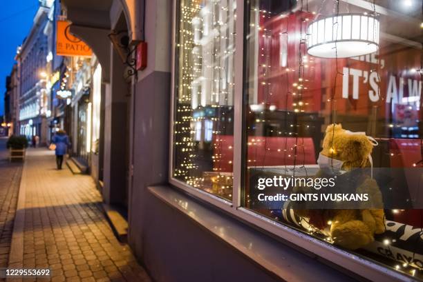 Restaurant with a teddy bear wearing a face mask in the window is pictured during the first day of Emergency restrictions amid the...