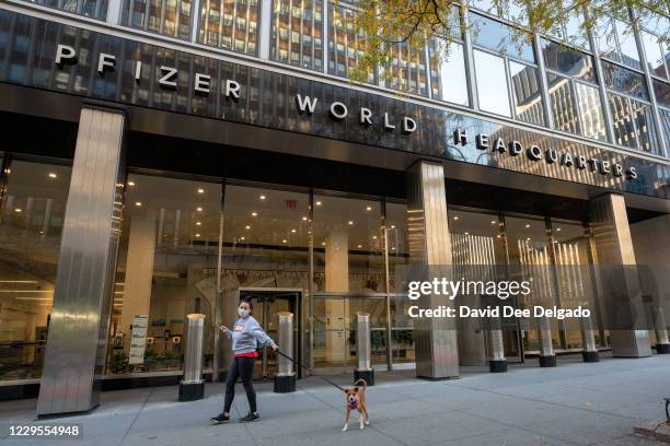 People walk by the Pfizer headquarters on November 9, 2020 in New York City. Pharmaceutical company Pfizer announced positive early results on its...