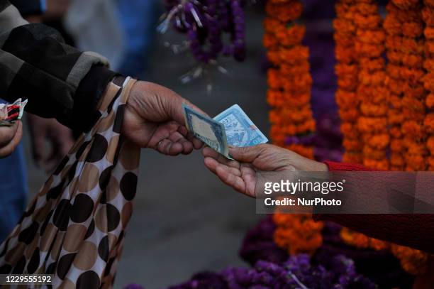 Nepalese people buying Gomphrena globosa 'makhmali flower' from the market for the Tihar festival celebration at Kathmandu, Nepal on November 09,...