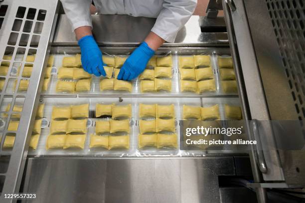 October 2020, Baden-Wuerttemberg, Crailsheim: An employee of the pasta producer Bürger GmbH & Co. KG aligns Maultaschen in the packaging. Photo:...