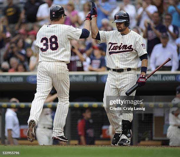 Luke Hughes second baseman for the Minnesota Twins celebrates with Jason Repko right fielder after Hughes hit a solo home run against Detroit Tigers...