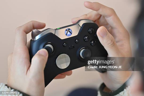 Visitor plays a game using Microsoft's Xbox controller at a flagship store of SK Telecom in Seoul on November 10, 2020.