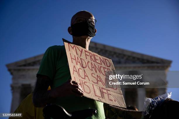 Supporter of the Affordable Care Act stands in front of the Supreme Court of the United States as the Court begins hearing arguments from California...