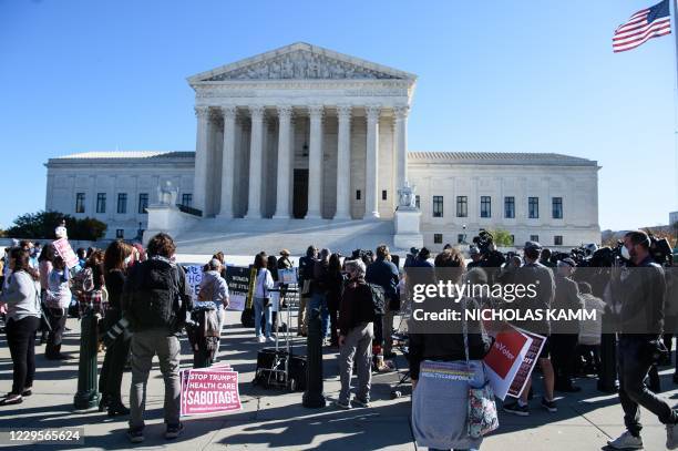 Demonstrators and reporters gather in front of the US Supreme Court in Washington, DC, on November 10 as the high court opened arguments in the...