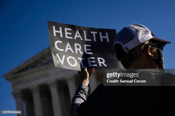 Supporter of the Affordable Care Act stands in front of the Supreme Court of the United States as the Court begins hearing arguments from California...