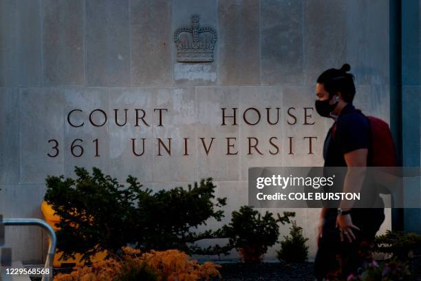 Man walks by the engraved signage outside the Superior Court of Justice in Toronto, Ontario, Canada on November 10 during the first day of the trial...
