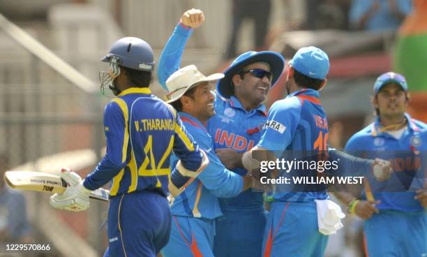 Indian fieldsman Virender Sehwag is congratulated by teammates Virat Kohli and Sachin Tendulkar after dismissing Sri Lankan batsman Upul Tharanga...