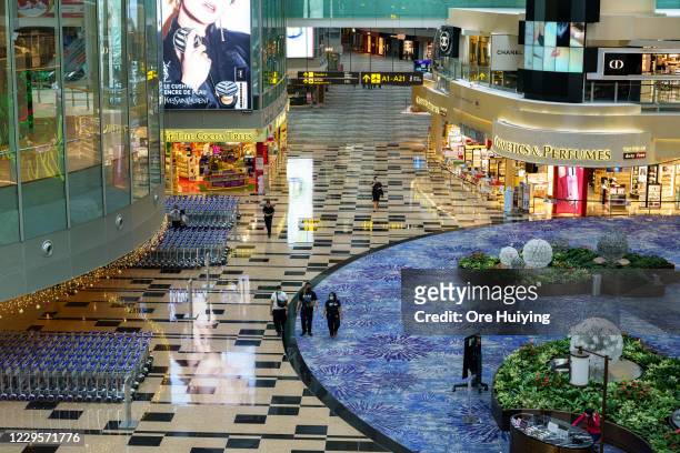 People walk past the departure hall after check in counter at Changi Airport Terminal 3 on November 11, 2020 in Singapore. Singapore and Hong Kong...