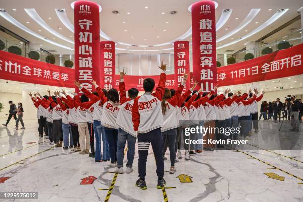Workers from Chinese e-commerce giant JD.com pose for photos during a break for Singles Day in the lobby at the company's headquarters as part of an...