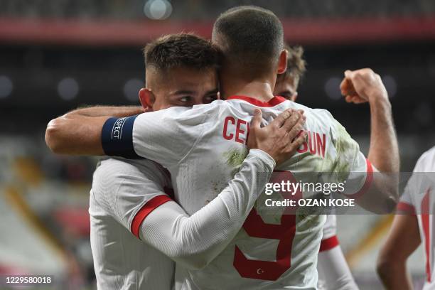 Turkey's forward Cenk Tosun celebrates with a teammate after scoring on a penalty kick during the friendly football match between Turkey and Croatia...