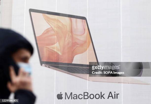 Man wearing a face mask as a preventive measure walks past a Mac Book Air by Apple advert in downtown Kiev. The so-called 'weekend quarantine' has...