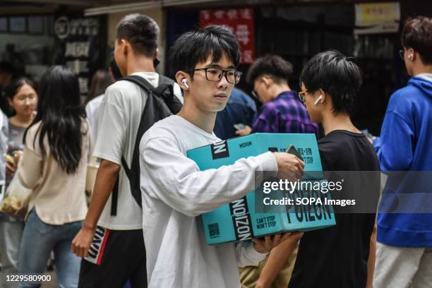 College student carrying packages at an online shopping pick up point during China's online shopping festival where businesses attract a lot of...