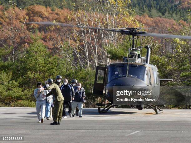 People take part in an emergency evacuation drill using a Japanese Ground Self-Defense Force helicopter in Higashidori in Aomori Prefecture,...