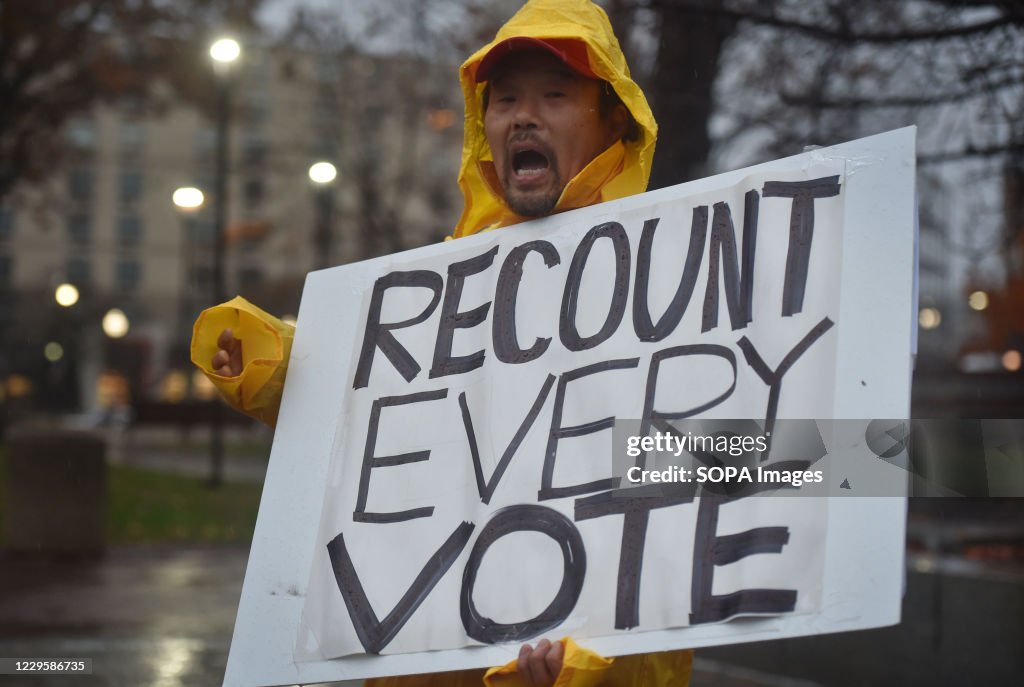 A protester holds a placard that says Recount Every Vote...