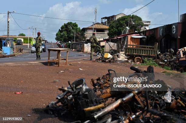 Ivorian soldiers inspect the rubbles of burnt shops in a street of M'Batto, on November 12, 2020 after inter-community violences broke out following...