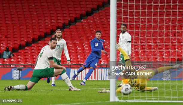 England's midfielder Jadon Sancho shoots past Republic of Ireland's goalkeeper Darren Randolph to score their second goal during the international...