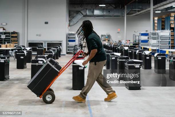 Worker wheels a box of 2020 Presidential election ballots to table for a hand-count during an audit at the Gwinnett County Voter Registration office...