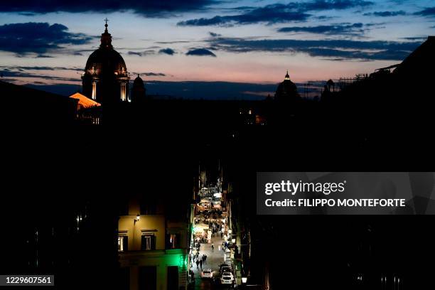 Picture shows a near-empty commercial street at dusk in central at Rome on November 13 amid the Covid-19 pandemic, caused by the novel coronavirus. -...