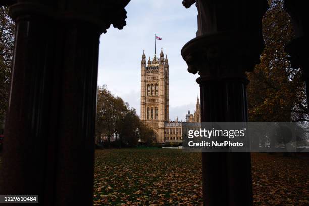 Union Jack flag flies from the top of the Victoria Tower of the Houses of Parliament, seen amid autumn leaf fall in Victoria Tower Gardens, in...