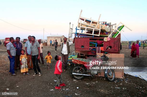 Ethiopians fleeing intense fighting in their homeland of Tigray, gather with their belongings in the bordering Sudanese village 8, east of the town...