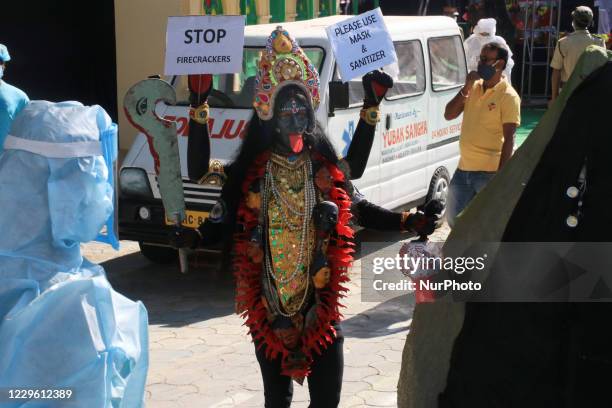 Krishna Bairagi a Bahurupi artist dressed as Hindu Goddess Kali strand and hold poster the Covid-19 awareness and awareness campaign on prohibition...