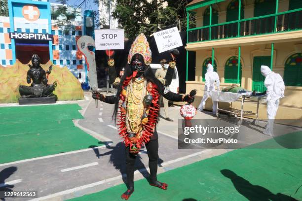 Krishna Bairagi a Bahurupi artist dressed as Hindu Goddess Kali strand and hold poster the Covid-19 awareness and awareness campaign on prohibition...