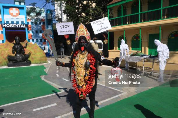 Krishna Bairagi a Bahurupi artist dressed as Hindu Goddess Kali strand and hold poster the Covid-19 awareness and awareness campaign on prohibition...