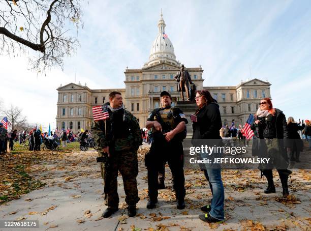 Armed security watch as people gather in support of US President Donald Trump at the Michigan State Capitol, on November 14, 2020 in Lansing,...