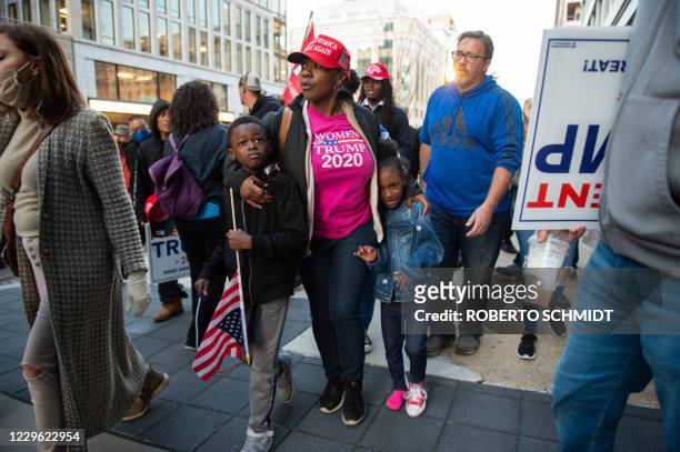 Woman holds her crying children after her family were harassed by anti-Trump demonstrators near Black Lives Matter in Washington, DC on November 14,...