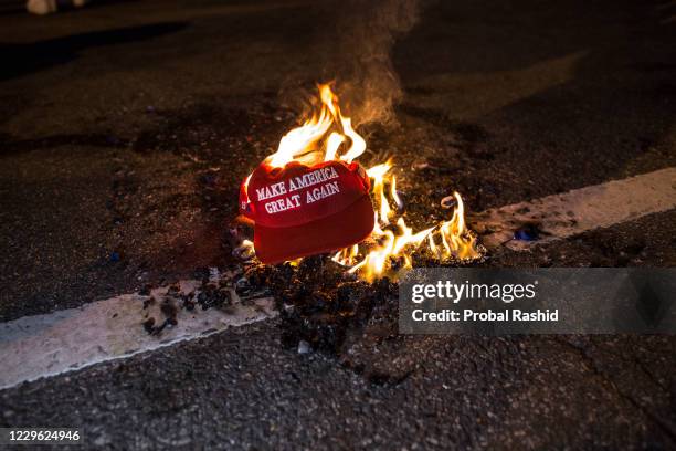 Black Lives Matter protesters burn a Trump Train hat prior to clashes with a group of Proud Boys following the "Million MAGA March" in Washington,...