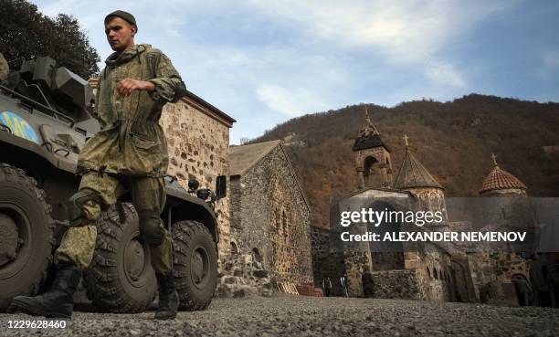 Russian peacekeeper walks past his Armoured Personnel carrier stationed in front of the 12th-13th century Orthodox Dadivank Monastery, outside the...