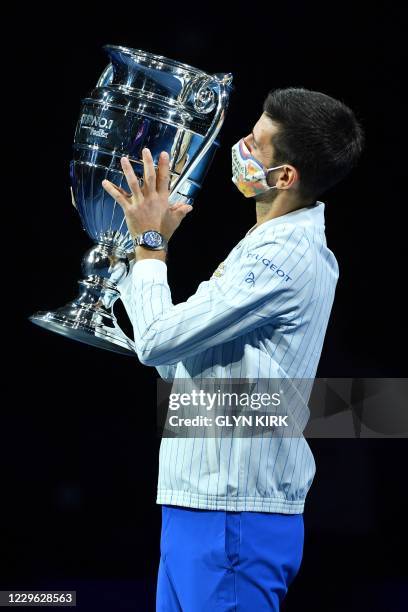 Serbia's Novak Djokovic holds up the 2020 ATP Tour Year-End Number One trophy at a presentation ceremony on day one of the ATP World Tour Finals...