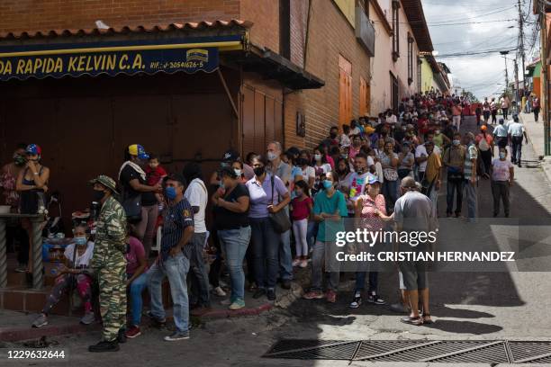 Venezuelans queue outside the Jose de Jesus Arocha public school in Petare, Caracas, during a mock election for the upcoming parliamentary vote, on...