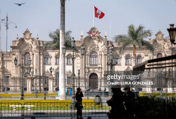 Police officers stand guard outside the Government Palace in Lima after Peruvian interim president Manuel Merino presented his resignation on...