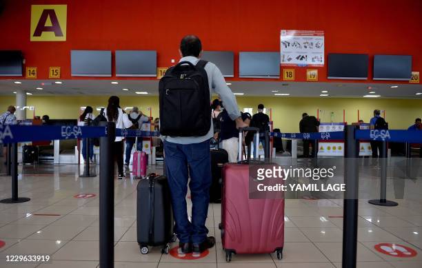 Passengers queue at the Copa Airlines counter at the Jose Marti International Airport as commercial flights resume in Havana on November 15 after...