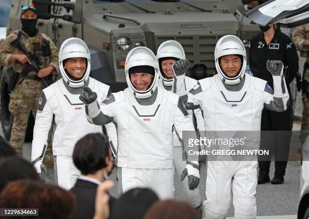 Crew-1 mission astronauts Victor Glover, Michael Hopkins, Shannon Walker and Japanese astronaut Soichi Noguchi, walk out of the Neil A. Armstrong...
