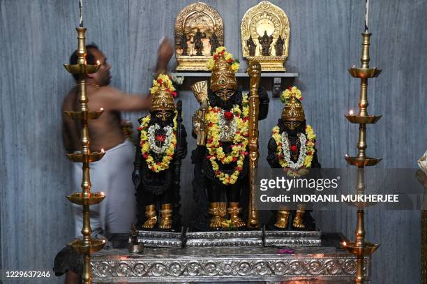Hindu priest anoints an altar and deities with sandalwood paste in a temple in Mumbai on November 16 after places of worships in Maharashtra state...